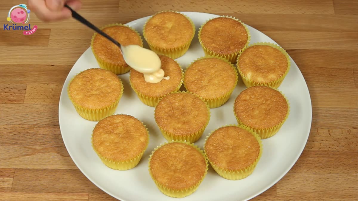 Fanta-Muffins backen: Saftig, locker und einfach gemacht - Guss auf die abgekühlten Muffins verteilen.
