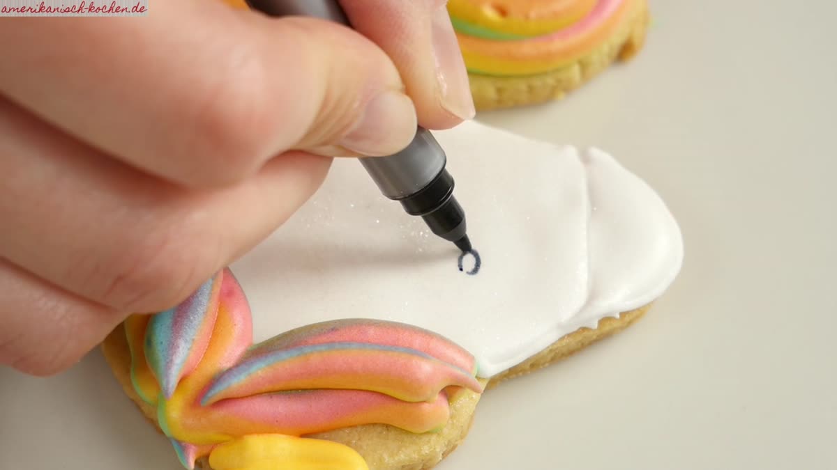 Unicorn Cookies backen: Rezept mit Regenbogen-Icing - Mit buntem Icing die Mähne und das Horn aufspritzen.
